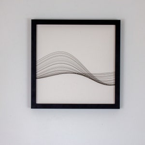 May include: Black framed wall art with a white background and a black string art design of a wave.