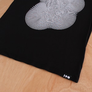 May include: Black tote bag with a white circular design and a black label with the text "I+O" on the bottom right corner.