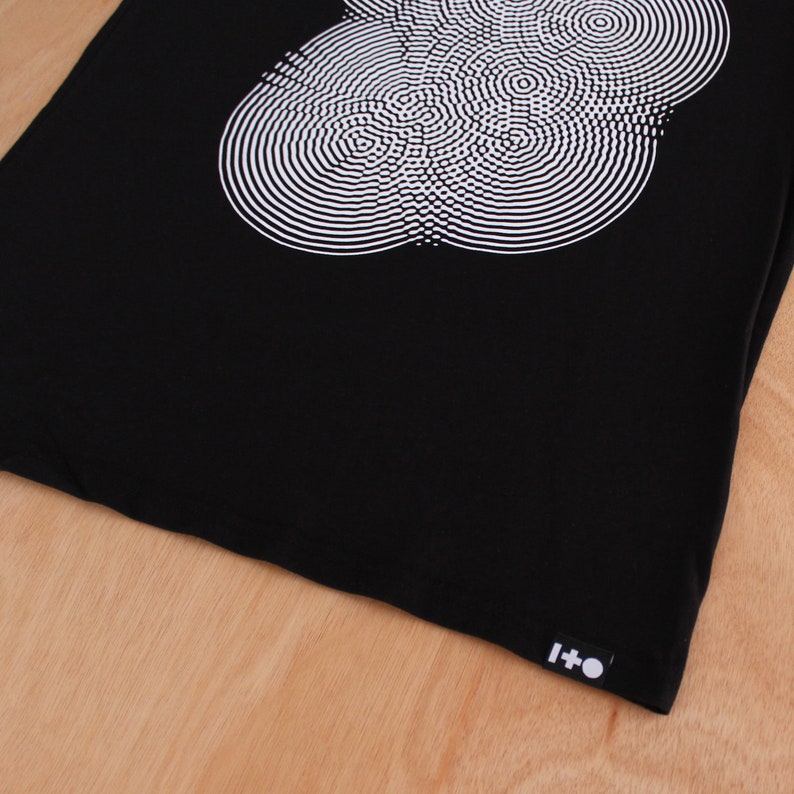 May include: Black tote bag with a white circular design and a black label with the text "I+O" on the bottom right corner.