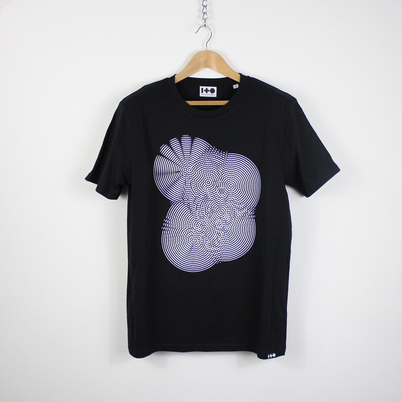 May include: Black t-shirt with a white and purple graphic print of a circular design. The shirt has a crew neck and short sleeves. The brand name "I-D" is printed on the tag.