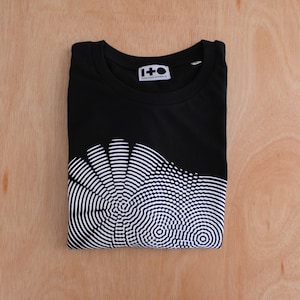 May include: Black t-shirt with a white graphic print of a circular pattern. The shirt has the text "1+O ONE AND OTHER.IO" on the front.