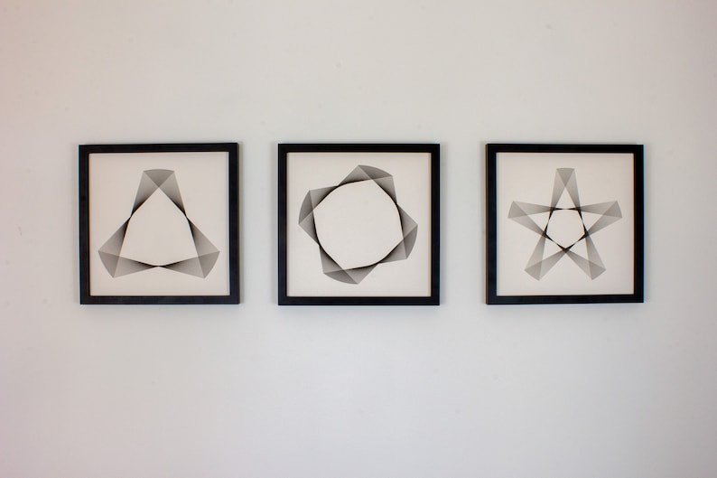 May include: Three black framed prints with white backgrounds and geometric designs. The designs are a triangle, a circle, and a star.