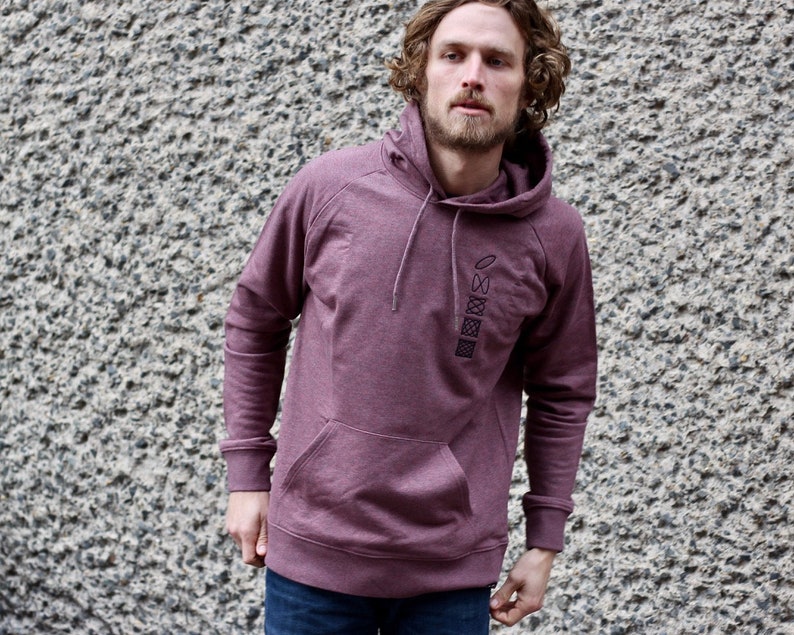 Op de afbeelding: Een bordeauxrood hoodie met een verticale rij van vijf zwarte geometrische ontwerpen op de voorkant.