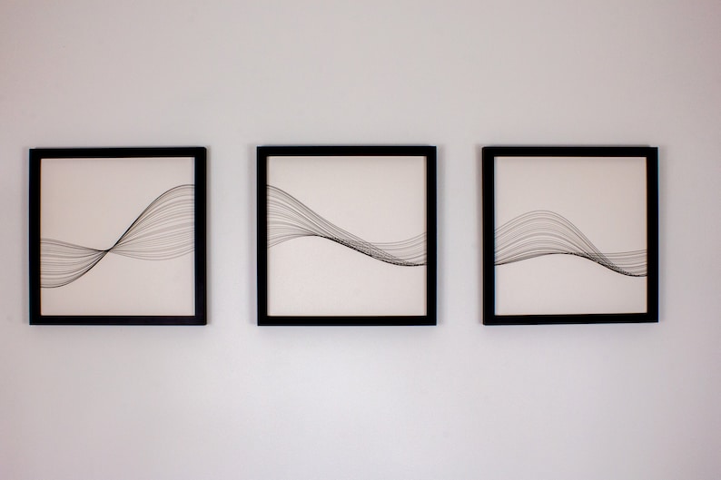 May include: Three black framed prints with white backgrounds and black line drawings of abstract waves.
