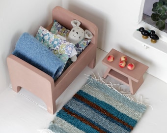 Miniature cot  with linen mouse, a small wooden stool and handmade rug.