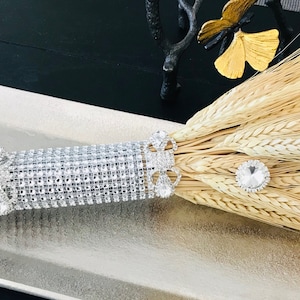 May include: A wheat bouquet wrapped in a silver rhinestone band with three rhinestone embellishments.