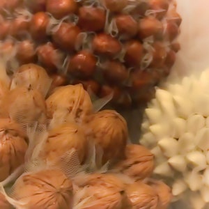 May include: A close-up of two different types of flower buds. The first is a cluster of brown, round buds, while the second is a white, star-shaped flower bud.