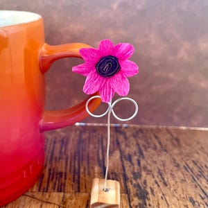 Scultura floreale rosa in carta realizzata a mano, con base in legno riciclato.