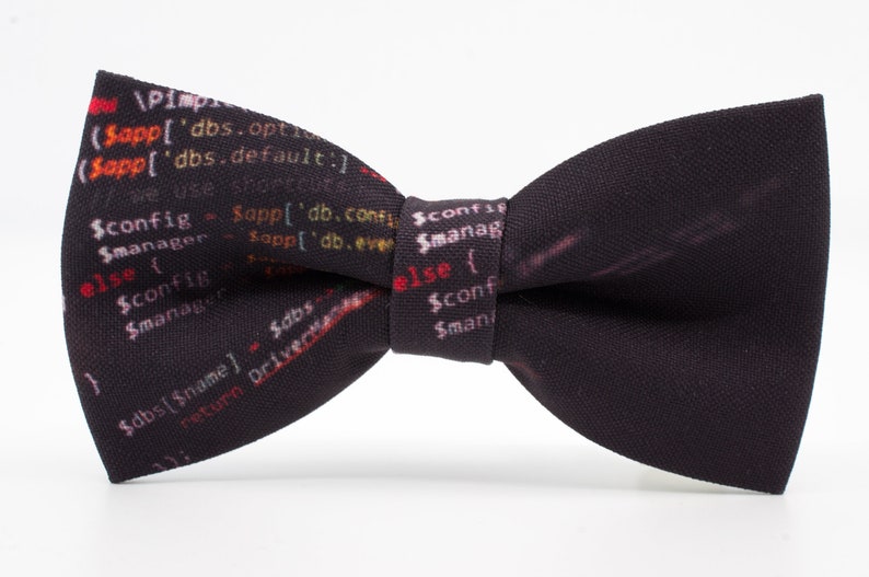 K&ouml;nnte beinhalten: Ein schwarzer Fliege mit einem Muster aus farbigem Code, der darauf gedruckt ist. Der Code enth&auml;lt den Text "$config", "$manager", "$dbs" und "$name".