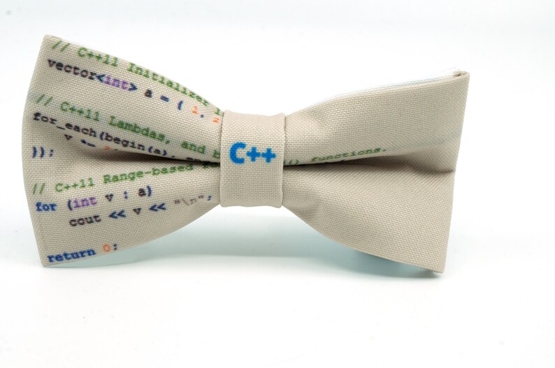 May include: A beige bow tie with a C++ logo and code printed on it. The code includes C++11 Initializer, Lambdas, and Range-based for loops.