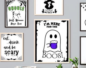 May include: Four Halloween-themed printable signs with black and white illustrations and text. The signs feature a skeleton couple dancing, a witch with a hat, a ghost holding a mug, and a spider web with the text "eat... drink... and be scary".