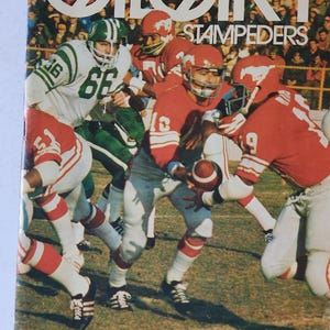 May include: A vintage magazine cover titled Calgary Stampeders featuring a colour photograph of football players in red and white uniforms competing against players in green and white uniforms on a field, with the text Canadian Football League Illustrated $1.