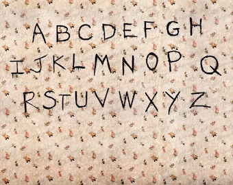 Könnte beinhalten: Schwarz-weiße Buchstaben des Alphabets auf einem beigefarbenen Hintergrund mit einem Blumenmuster. Die Buchstaben sind in einem tropfenden Stil geschrieben, als wären sie mit einem Pinsel gemalt.