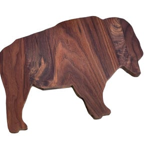 May include: A wooden cutting board shaped like a buffalo, made from dark walnut wood.
