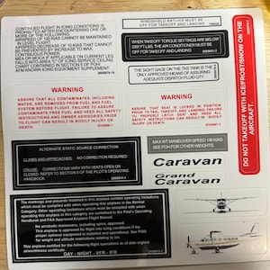May include: A collection of aviation safety placards and operational information for a Caravan and Grand Caravan aircraft. The placards include warnings about icing conditions, fuel contamination, and seat locking procedures. The image also shows aircraft diagrams.