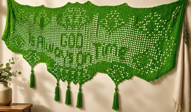 May include: A vibrant green, crocheted wall hanging with the words "Good Things" in a decorative font. The piece has a scalloped edge and is adorned with green tassels. The background is a neutral wall.