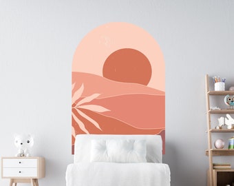 May include: A white armchair with a white pillow sits in front of a peach and orange arch wall decal with a sun and palm tree design. A white stuffed animal sits on the floor in front of the chair.