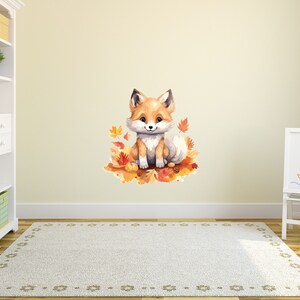 May include: A watercolor illustration of a cute orange fox sitting on a bed of autumn leaves. The fox has a white chest and a fluffy tail.