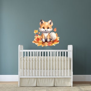 May include: A cute orange fox with a white chest and tail sits on a bed of orange and yellow leaves. The fox is looking at the camera with a friendly expression. The image is a nursery wall decal.