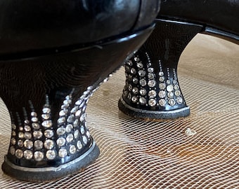 Peut inclure: Gros plan sur une paire de chaussures noires à talons hauts avec un motif de strass sur les talons.