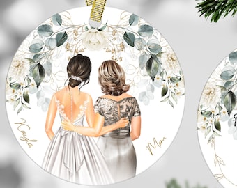May include: Two round white baubles with gold trim and floral designs. One bauble features a bride and her mother in white dresses. The other bauble has the text "Thank you for your support and care I'll always be grateful for the love we share!"
