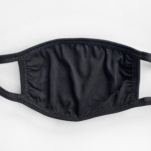 May include: A black face mask made of soft fabric with elastic ear loops. The mask is plain and has no design or pattern.