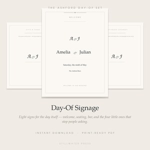 May include: A set of three off-white wedding signs featuring black serif typography. The central sign displays the text The Ashford Day-Of Set, Welcome, A & J, Amelia & Julian, Saturday, the ninth of May, The Ashford Barn, and Welcome to our wedding.
