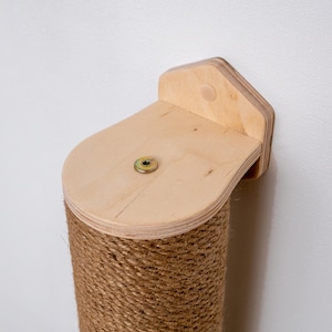 Puede incluir: Un rascador para gatos de madera con una cuerda de sisal que lo cubre. El poste est&aacute; fijado a la pared con un soporte de madera. El soporte tiene un tornillo en el centro.