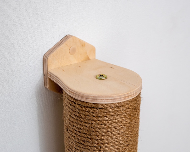 Puede incluir: Un rascador para gatos de madera con una cuerda de sisal que lo cubre. El poste est&aacute; fijado a la pared con un soporte de madera. El soporte tiene una forma redondeada y un peque&ntilde;o agujero en el centro.