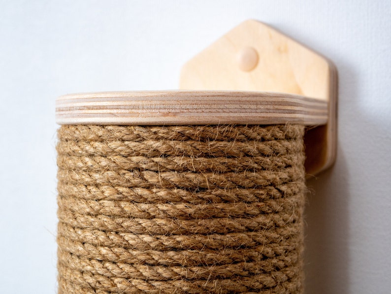 Cat scratcher natural wood color with jute rope and hexagonal base mounted to the wall