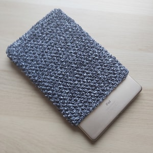 Peut inclure: Une housse pour iPad en tricot gris et blanc avec le mot "iPad" imprimé au dos d'un iPad doré.