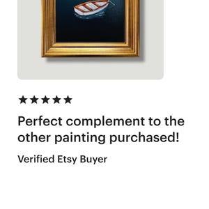 May include: A framed painting depicting a small boat on dark blue water. The boat is white and brown, and the frame is gold. The painting is square and is displayed on a white background.