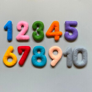 May include: Felt numbers 1 to 10 in various colours. The numbers are arranged in two rows, with the first row containing numbers 1 to 6 and the second row containing numbers 7 to 10.