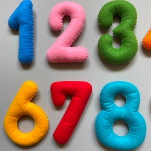 May include: Felt numbers 1 to 8 in different colours. The numbers are sewn together and have a soft, plush texture.