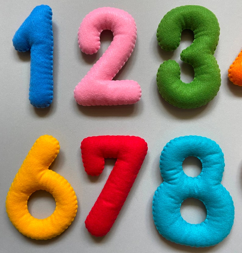 May include: Felt numbers 1 to 8 in different colours. The numbers are sewn together and have a soft, plush texture.