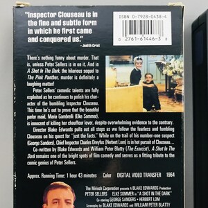 May include: A VHS tape cover for the movie "A Shot in the Dark" starring Peter Sellers as Inspector Clouseau. The cover features a black and white photo of Sellers in character, along with the movie title and a quote from Judith Crist. The cover also includes the movie's running time, color, and digital video transfer information.
