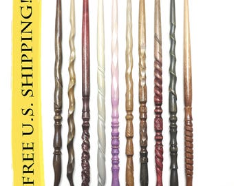 May include: A collection of ten wooden wands arranged vertically and numbered 11 through 20. Each wand features a unique carved texture, including spiral, twisted, and smooth designs in various shades of brown, grey, and light pink.