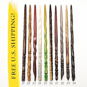May include: A collection of ten slender wooden wands arranged vertically, numbered 21 through 30. Each wand features a unique carved texture, including spiral, twisted, and segmented designs in various shades of brown, cream, green, and black.