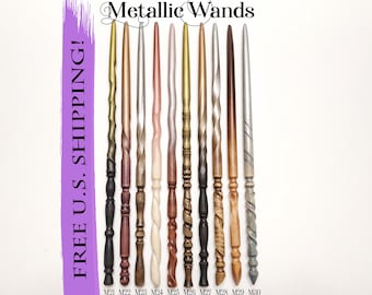 May include: Ten wooden wands with metallic finishes. The wands are arranged in a row from left to right. The wands are all different colors, including gold, silver, bronze, copper, and rose gold. The wands are all about 12 inches long. The text "FREE U.S. SHIPPING!" is written in purple on a white background on the left side of the image. The text "Metallic Wands" is written in black on a white background at the top of the image. The text "M21 M22 M23 M24 M25 M26 M27 M28 M29 M30" is written in black on a white background at the bottom of the image.