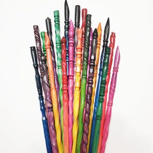 Pode incluir: Uma cole&ccedil;&atilde;o de varinhas de madeira coloridas, esculpidas &agrave; m&atilde;o, em v&aacute;rias formas e tamanhos. As varinhas s&atilde;o pintadas em tons vibrantes de azul, verde, vermelho, rosa, amarelo e roxo. Algumas t&ecirc;m desenhos torcidos ou em espiral, enquanto outras t&ecirc;m pontas pontiagudas ou arredondadas.
