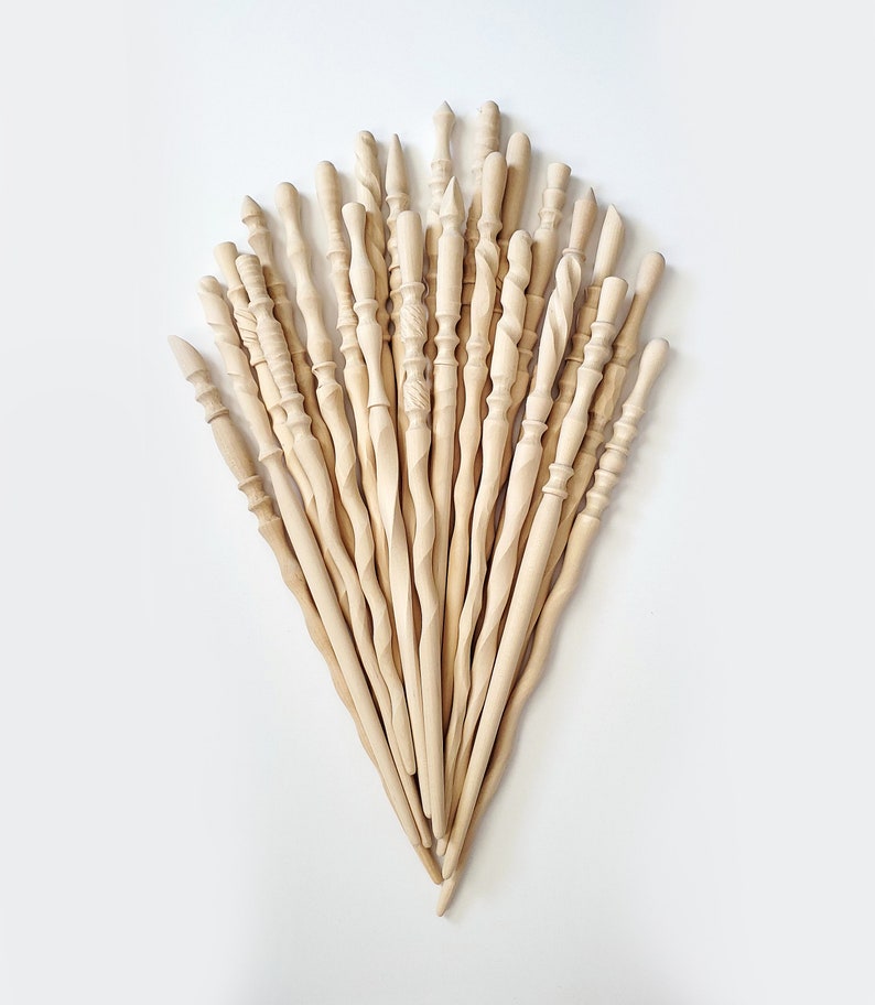 May include: A collection of 20 wooden wands, each with a unique design and shape. The wands are all natural wood color and are arranged in a fan shape.
