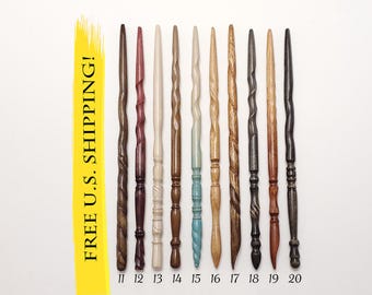May include: A collection of ten wooden wands arranged vertically, numbered 11 through 20. Each wand features a unique carved design, varying in color from light cream and natural wood tones to deep brown, reddish-purple, black, and a light blue.