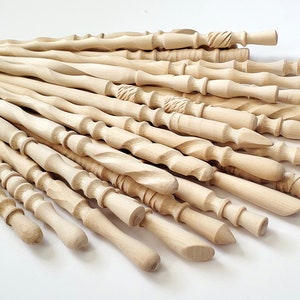 May include: A collection of 20 wooden wands, each with a unique design and shape. The wands are made of light-colored wood and have a smooth, polished finish.