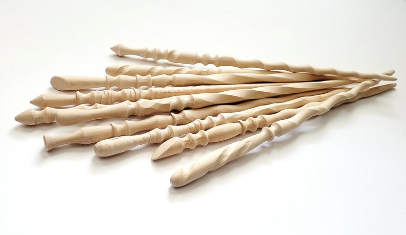 May include: A group of 10 unfinished wooden wands, each with a unique twist and shape. The wands are made of light-colored wood and are approximately 12 inches long.