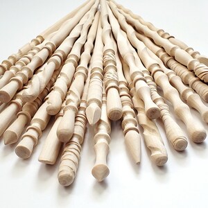 May include: A collection of 20 unfinished wooden wands, each with a unique design and shape. The wands are made of natural wood and have a smooth, polished finish.