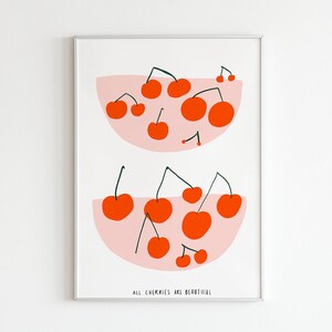 Könnte beinhalten: Ein weißer gerahmter Druck mit zwei rosa Schalen gefüllt mit roten Kirschen. Der Text "All cherries are beautiful" befindet sich am unteren Rand des Drucks.