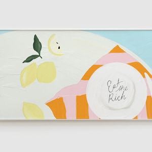 Könnte beinhalten: Gerahmtes Gemälde mit weißem Hintergrund, das Zitronen, einen Teller mit dem Text "Eat the Rich" und ein rosa-orangefarbenes Streifenmuster zeigt. Das Kunstwerk hat einen modernen, minimalistischen Stil.