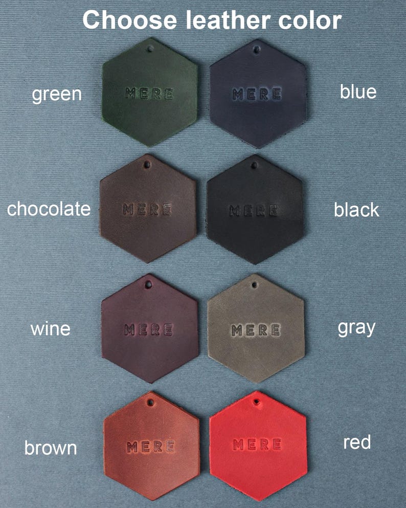 May include: Nine leather swatches in hexagon shapes, each with the word "MERE" embossed in the center. The swatches are arranged in three rows of three, with the colors green, blue, black, wine, gray, red, chocolate, and brown.