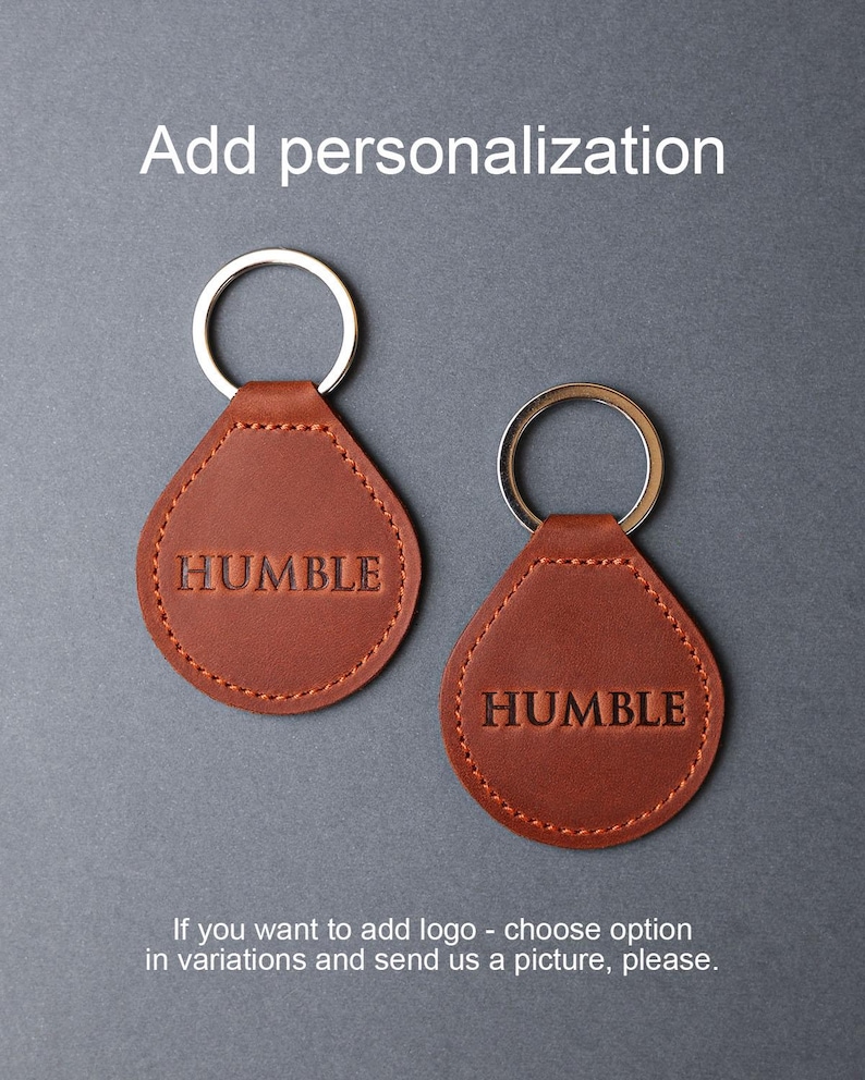 May include: Two brown leather keychains with silver key rings. The keychains are shaped like teardrops and have the word "HUMBLE" embossed on them.