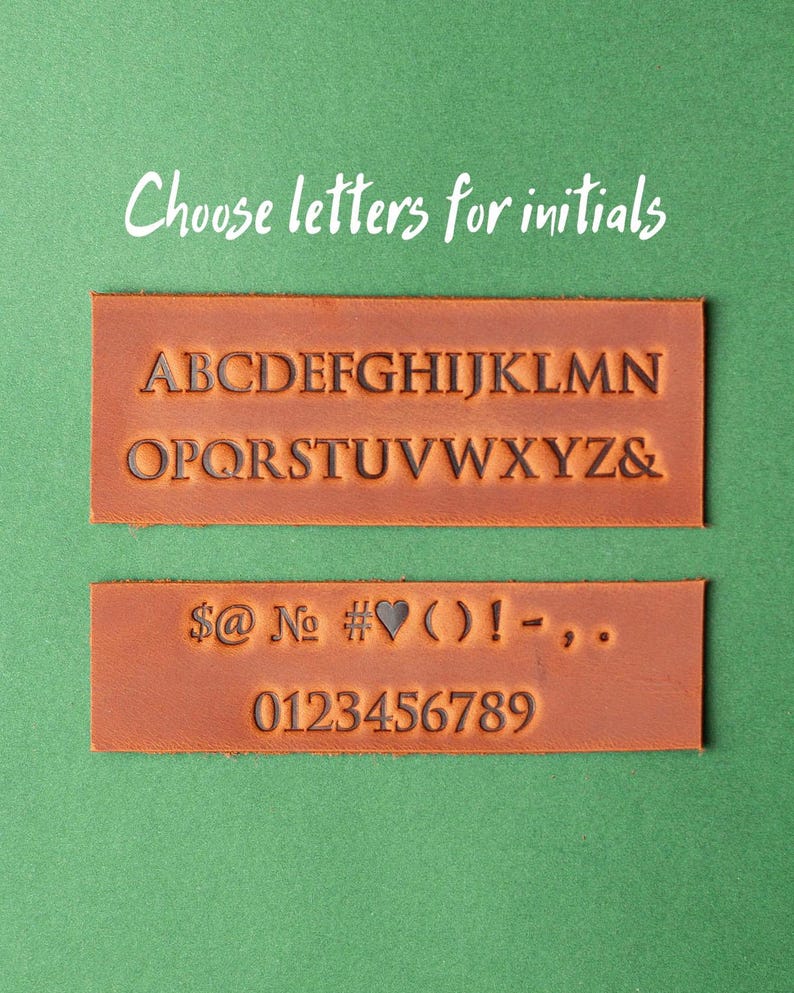 May include: Two brown leather strips with black lettering. The top strip has the alphabet in uppercase letters. The bottom strip has symbols, numbers, and the word "No".